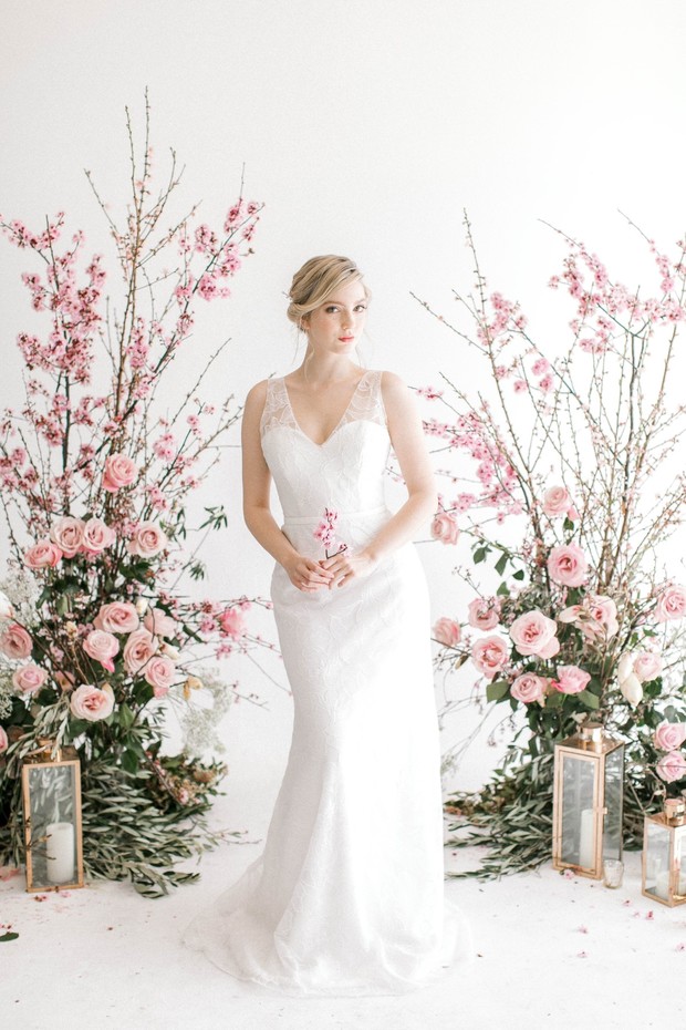 Bride in white wedding dress holding pink flower posy