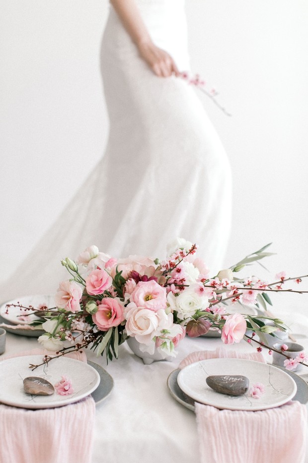 Elegant bride stands near a floral centerpiece table setting
