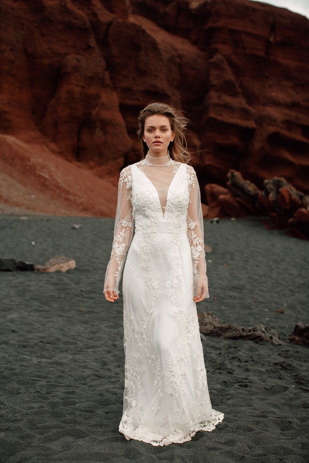 Elegant bride in white dress on black sand and volcanic rocks