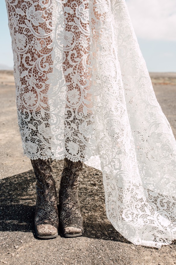 A bride in lace dress with cowboy boots on her feet