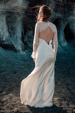 Elegant bride in a flowing wedding dress on a textured background