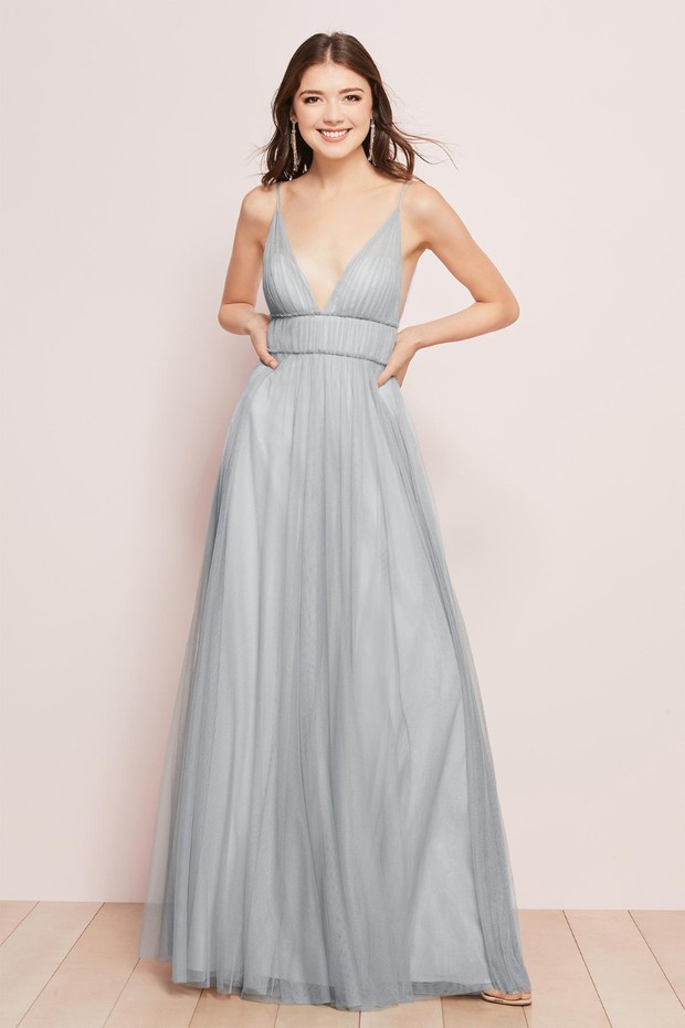 Elegant woman in a flowing pale blue tulle formal dress posing