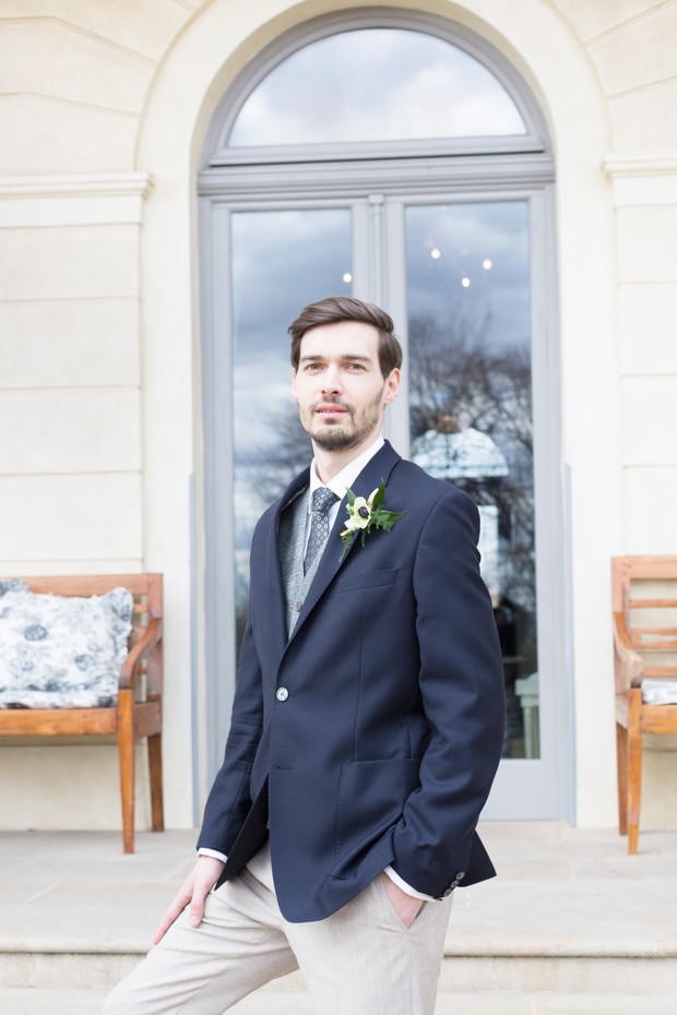 groom in navy suit jacket and sand colored trousers