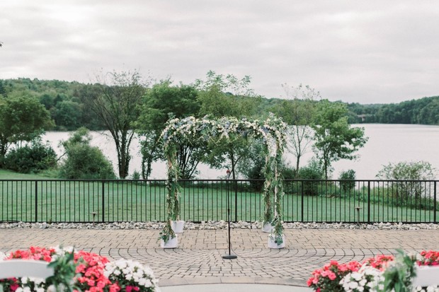 Outdoor wedding venue with floral arch and lake view