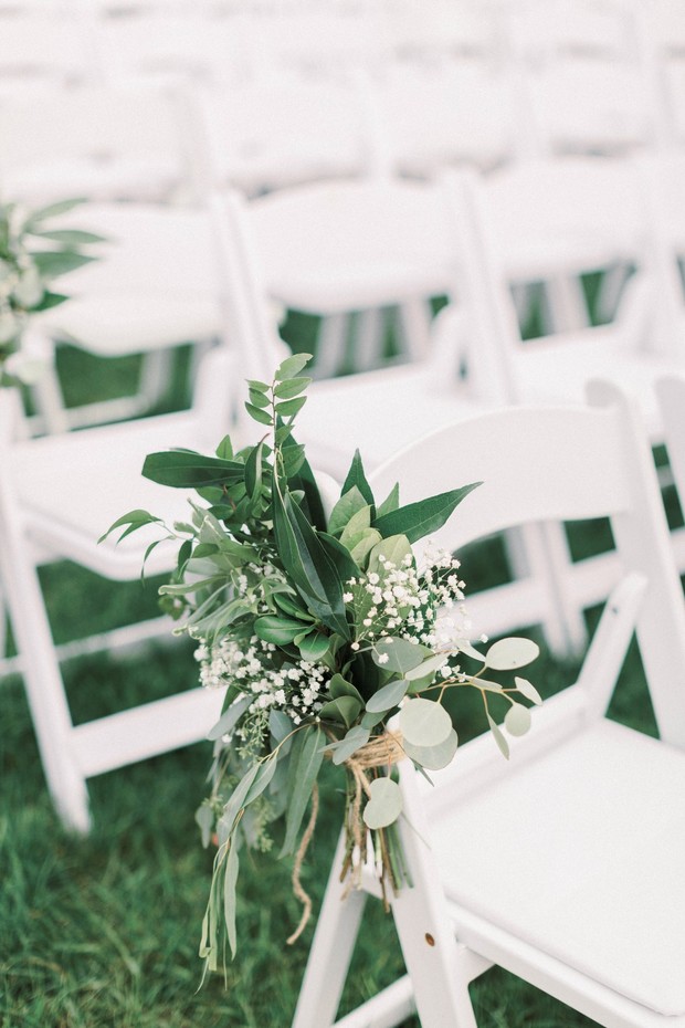 Floral aisle decor on white wedding chairs outdoor