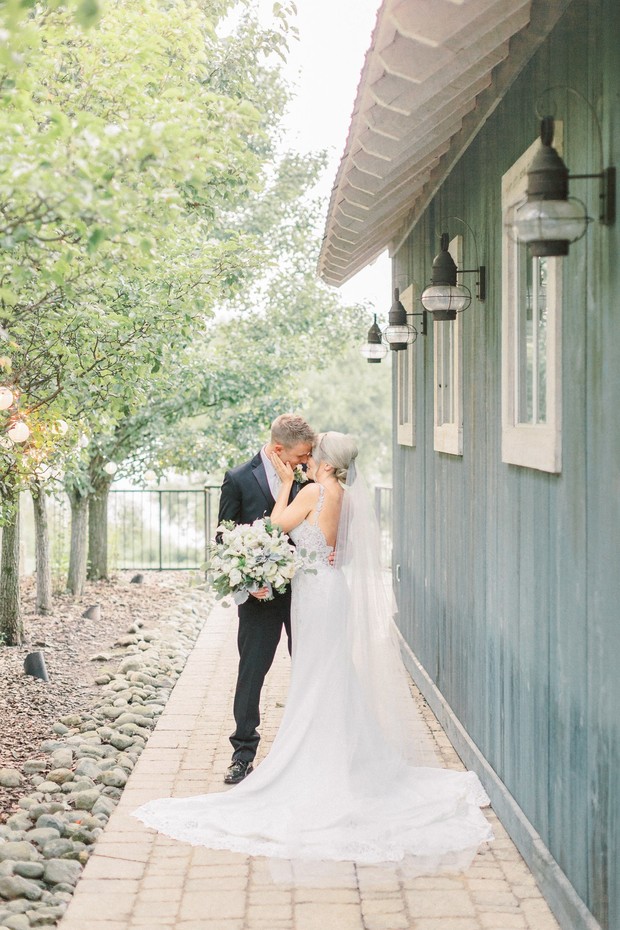 Bride and groom embrace during outdoor wedding ceremony
