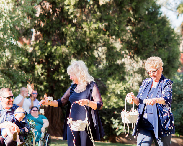 Two ladies with flower baskets at an outdoor wedding