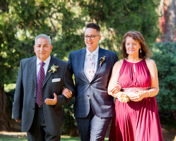 Groom walking down the aisle with parents at wedding ceremony