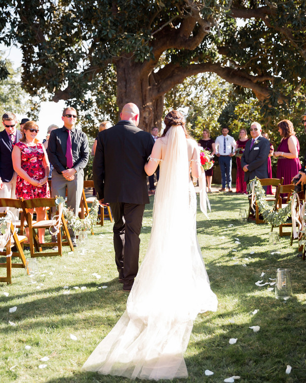 Bride walks down the aisle at an outdoor wedding ceremony
