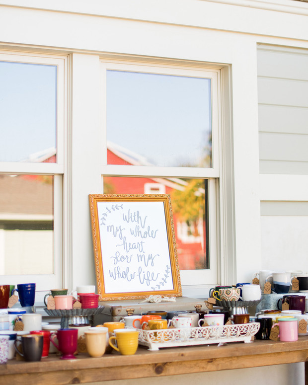 Display of mugs with decorative sign and window backdrop