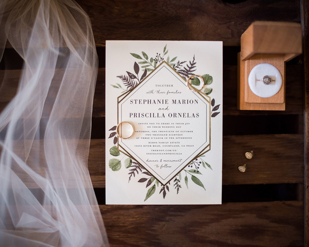 Elegant wedding invitation with rings and floral accents