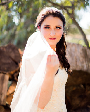 Bride in a beautiful wedding dress and veil smiles for the camera
