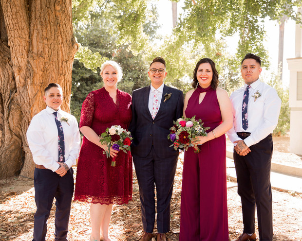 Wedding party smiling together in a beautiful outdoor setting with bouquets