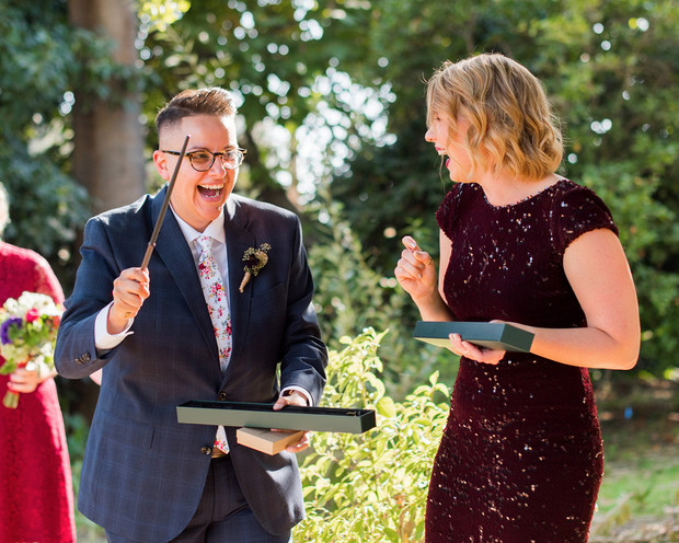 Two women excitedly opening a gift at an outdoor event