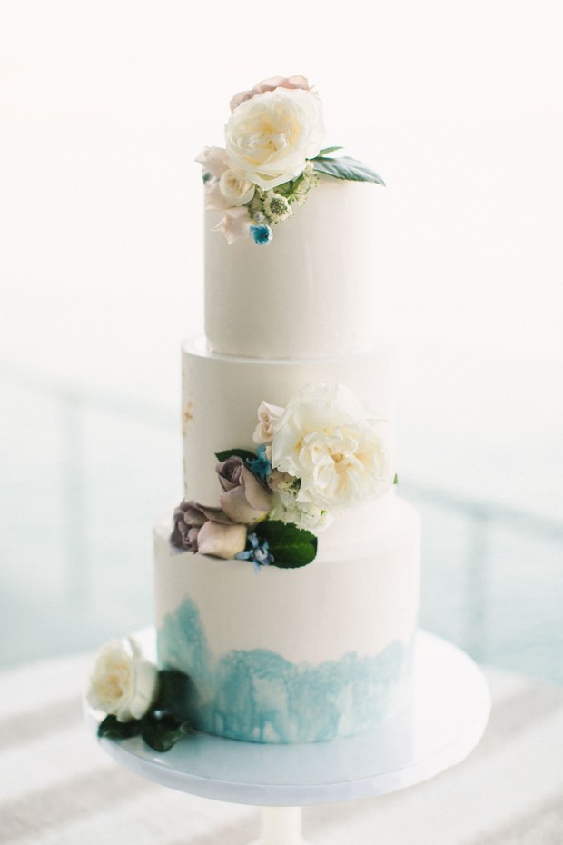 flower topped blue and white wedding cake