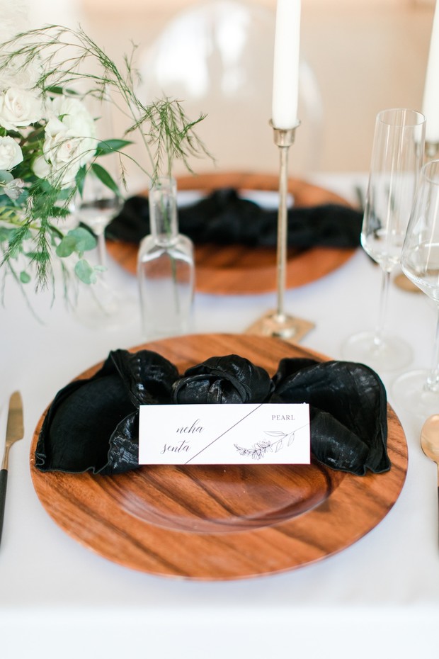 wooden wedding plates with black bow tie tied linens
