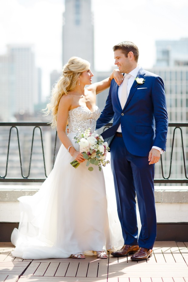 Elegant bride and groom gaze at each other on a rooftop wedding day