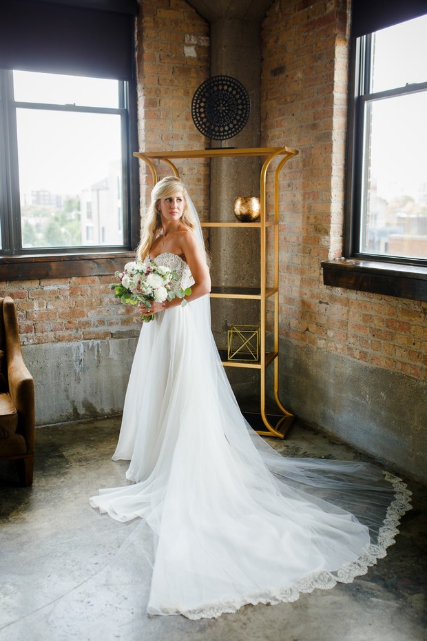 Beautiful bride in a wedding gown holds flower bouquet