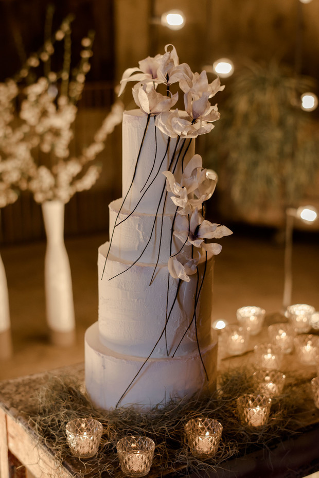 dramatic wedding cake with floral decor and candle light
