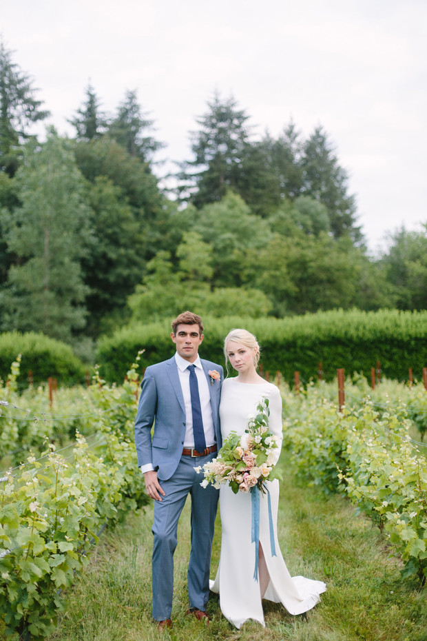 Elegant couple pose for wedding photos in a vineyard