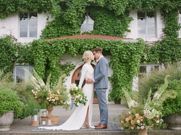 Romantic wedding kiss in front of a ivy covered building
