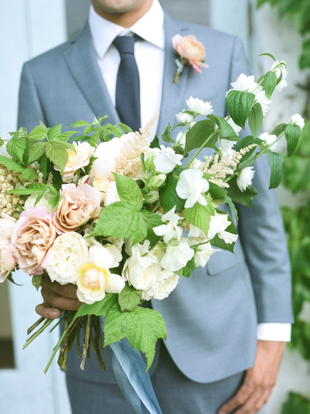 Man in suit holding a beautiful bouquet of wedding flowers