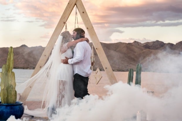 dreamy desert wedding with white smoke bomb kiss