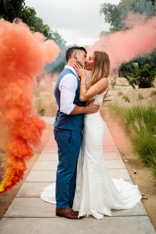 romantic wedding kiss with orange smoke