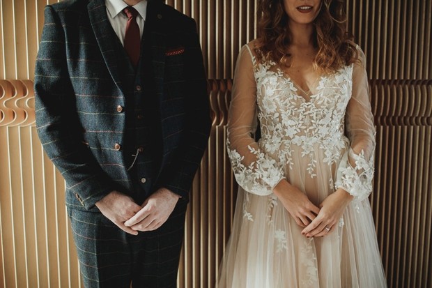 groom in gold print suit and bride in romantic dress