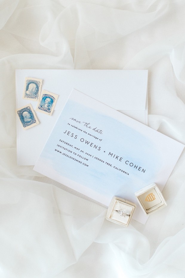 Wedding invitation with rings and stamps on white fabric