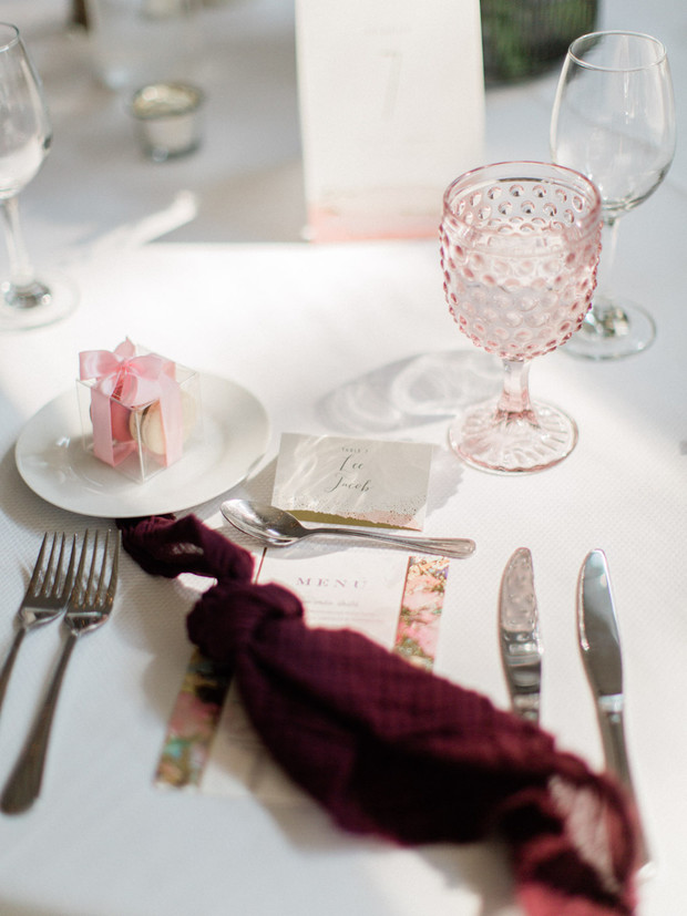 Elegant table setting with pink glass and wedding favors