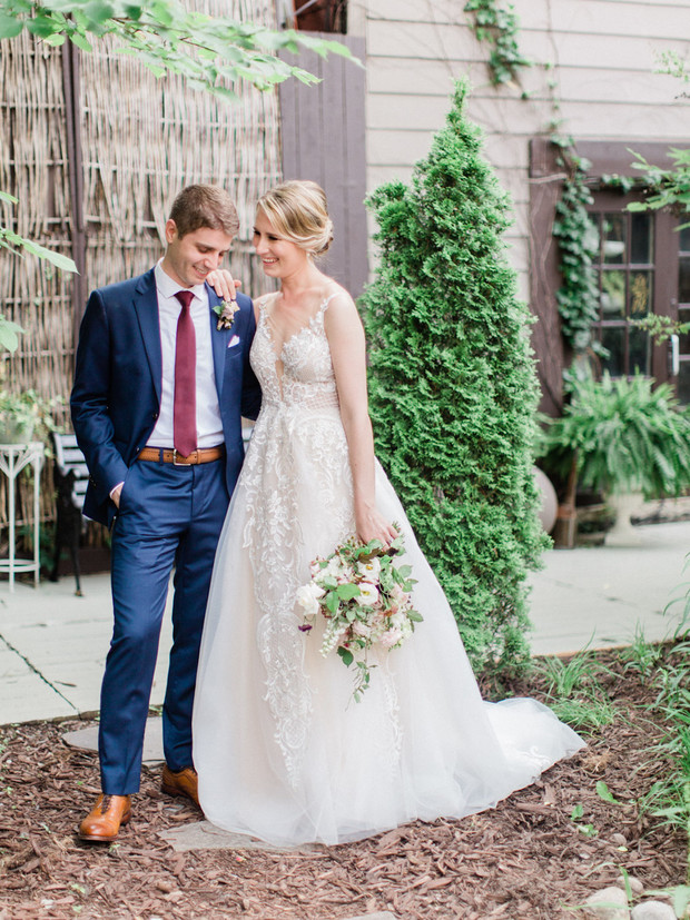 Happy bride and groom pose for wedding photo outdoors