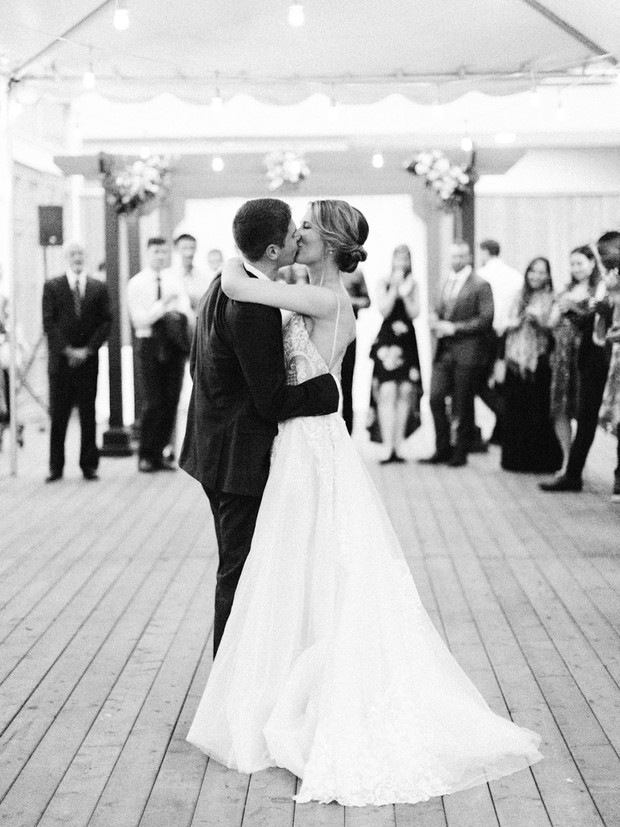 Bride and groom share a kiss during their first dance at wedding