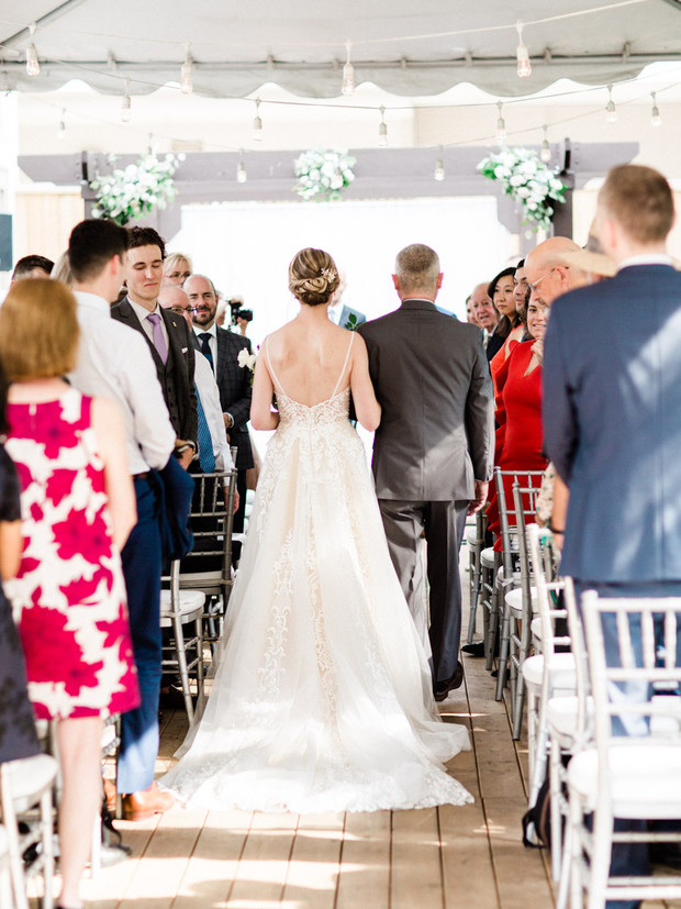 Bride walking down the aisle with her father at an outdoor wedding