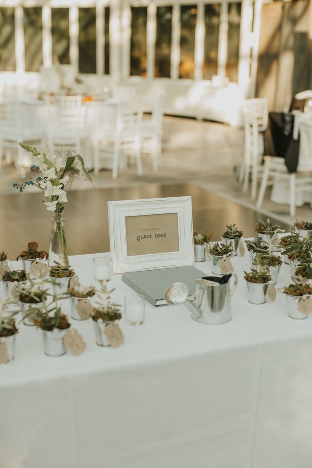 Wedding guest book table with potted succulents and decor
