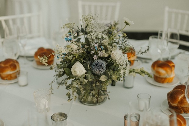 Elegant wedding table setting with floral centerpiece and bread rolls