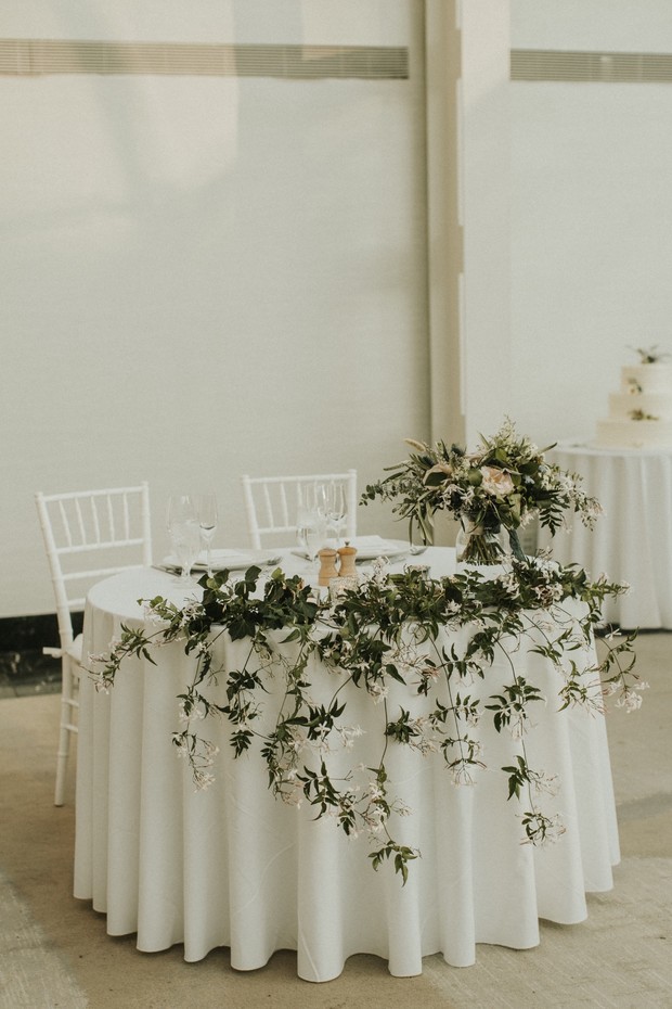 Wedding table decor with floral garland and white linens
