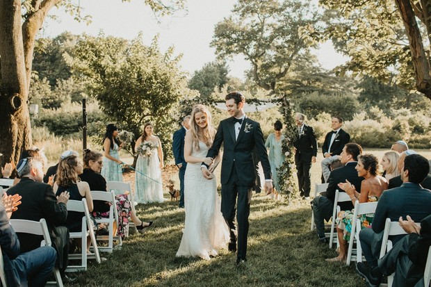Newly wedded couple walking down the aisle at an outdoor wedding ceremony