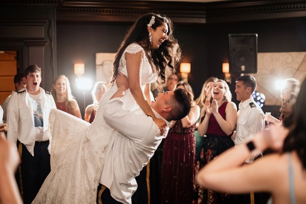 Happy bride and groom lift celebrating their wedding with guests