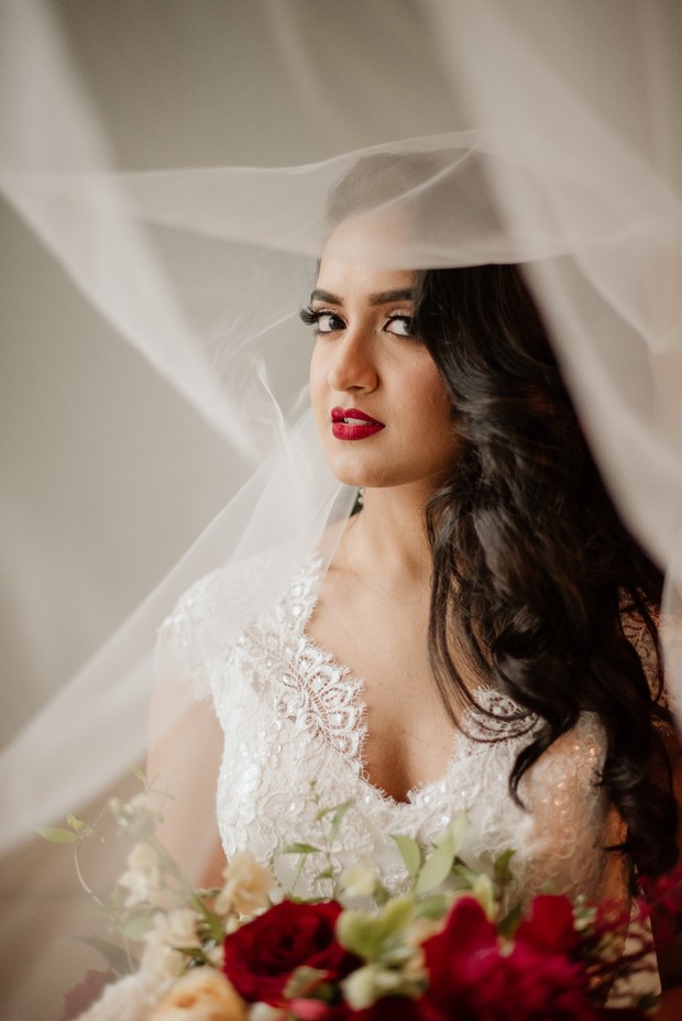 Beautiful bride in white gown and veil, with a bouquet