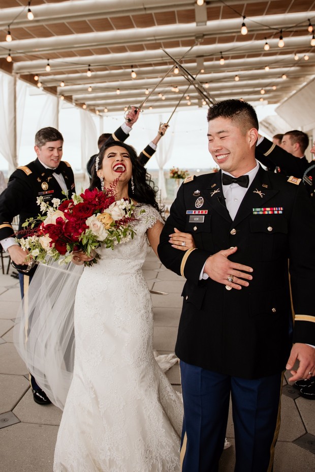 Joyful military couple celebrating wedding, sword arch overhead