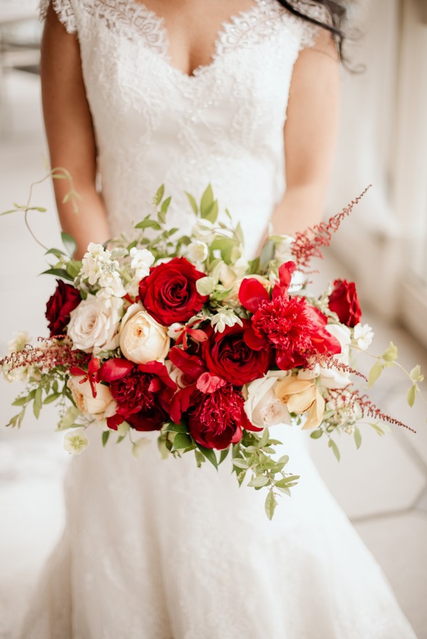 Bride holding a red rose bouquet on her wedding day