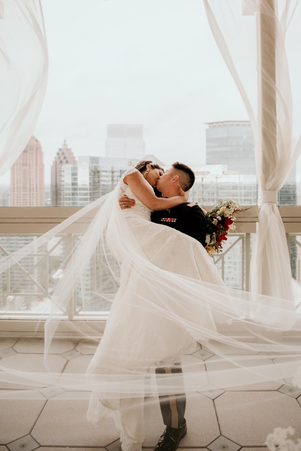 Bride and groom sharing a kiss with a city view backdrop