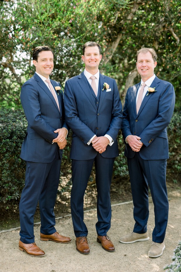 groom and his men in navy blue suits and blush ties
