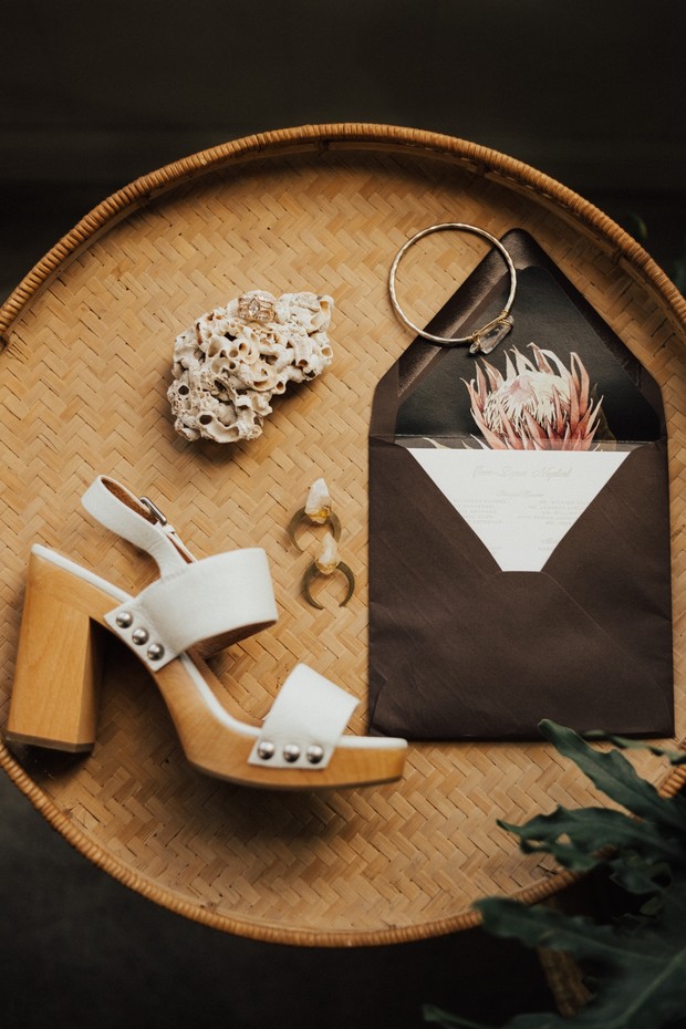 Wedding details white sandal and invitation on basket