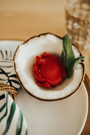 Red sorbet served in a coconut shell with fresh mint