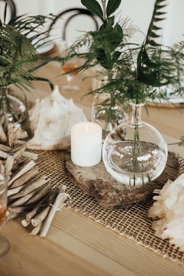 Rustic table setting with candles driftwood and greenery