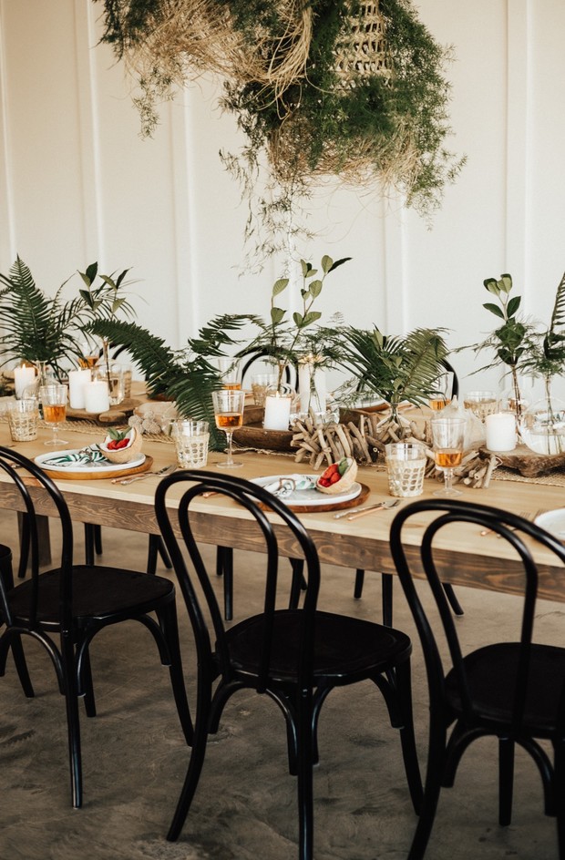 Rustic wooden dining table with tropical greenery decor