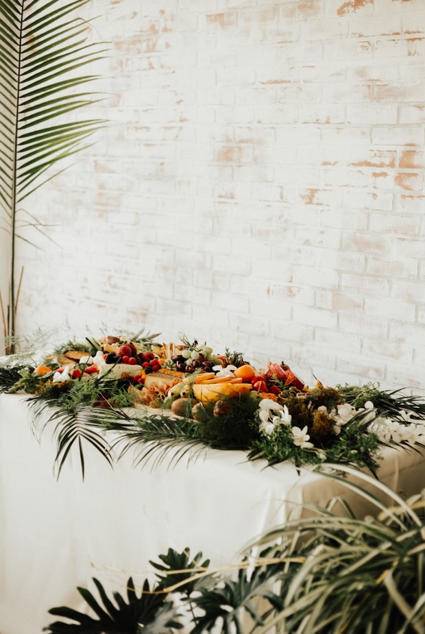 Elegant fruit and cheese grazing table with green accents
