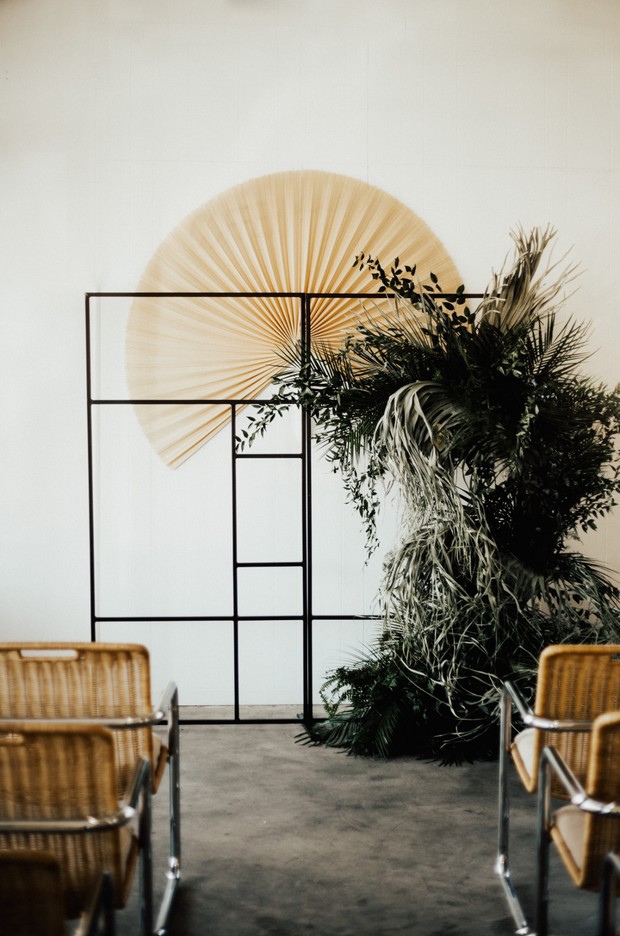Modern wedding altar with geometric frame and wicker chairs